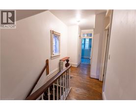 A hallway with a wooden staircase and white walls.