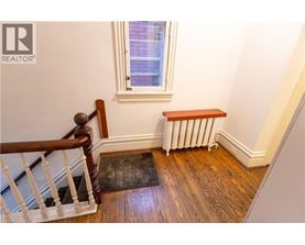 A room with a window, a radiator, and a wooden bench.