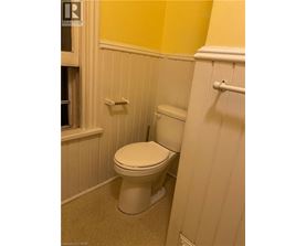 A white toilet in a bathroom with yellow walls.