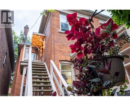 A house with a red brick exterior and a white staircase leading to the second floor.