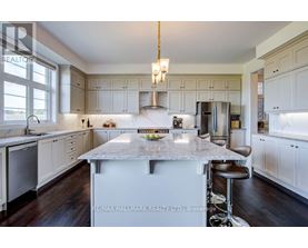 A kitchen with white cabinets and a marble island.