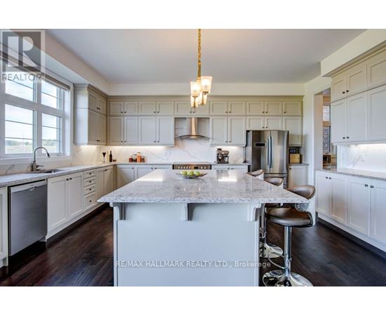 A kitchen with white cabinets and a marble island.