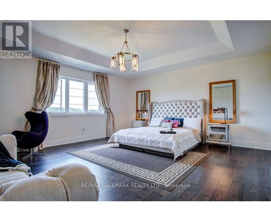 A bedroom with a large bed and a chair.