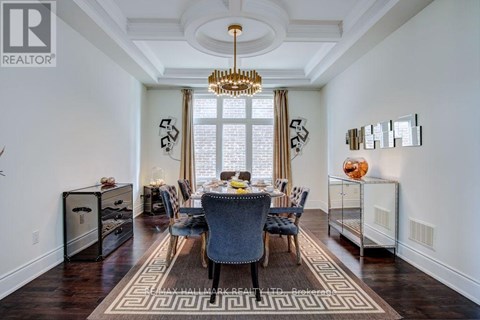 A dining room with a table set for six and a chandelier hanging from the ceiling.