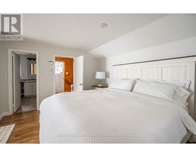 A bedroom with a large bed and a small closet.