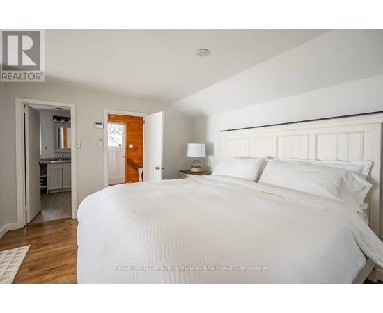 A bedroom with a large bed and a small closet.