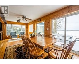 A dining room with a wooden table and chairs.