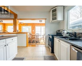 A kitchen with white cabinets and a black counter top.