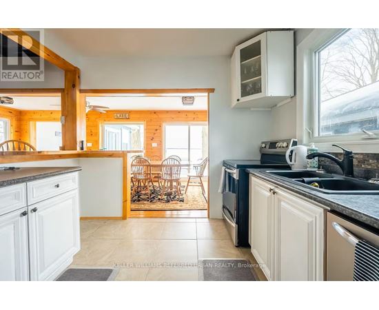 A kitchen with white cabinets and a black counter top.