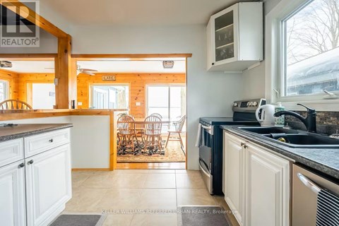 A kitchen with white cabinets and a black counter top.