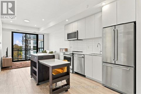 A modern kitchen with stainless steel appliances and a large island.