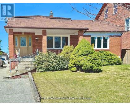 A house with a red brick exterior and a green lawn in front.