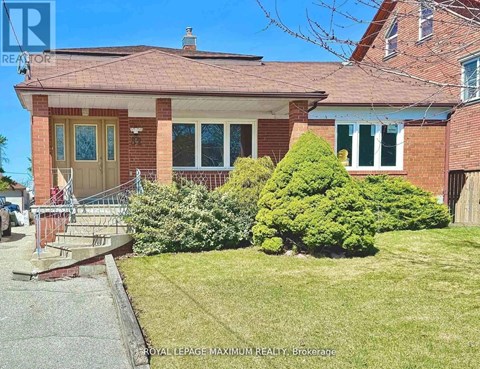 A house with a red brick exterior and a green lawn in front.