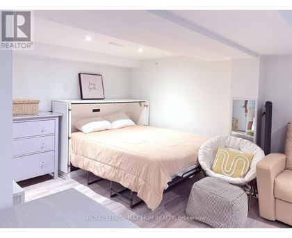 A bedroom with a bed, chair, and nightstand.