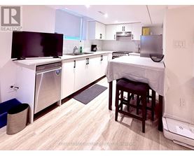 A small kitchen with a bed in the corner.