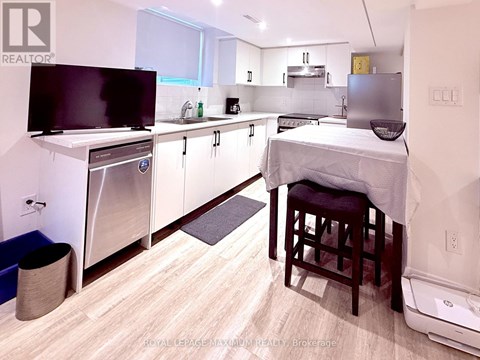 A small kitchen with a bed in the corner.
