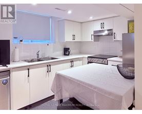 A white kitchen with a bed in the middle.