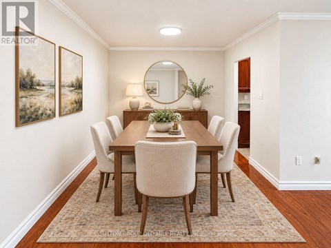 A dining room with a wooden table and chairs.
