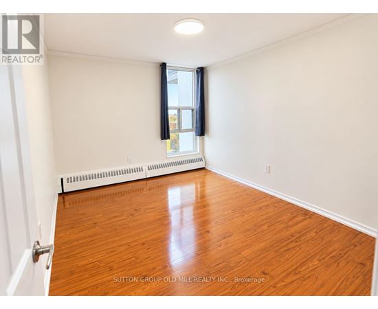 A room with wooden flooring and a window with blinds.