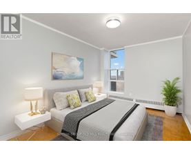 A bedroom with a bed, nightstands, and a painting on the wall.