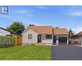 A house with a brown roof and a garage door is for sale.