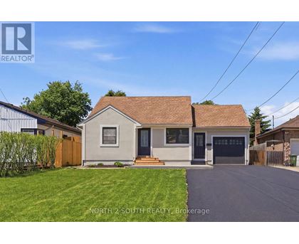 A house with a brown roof and a garage door is for sale.