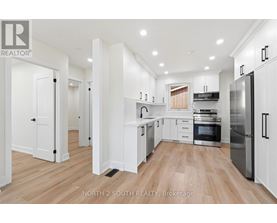 A modern kitchen with white cabinets and stainless steel appliances.
