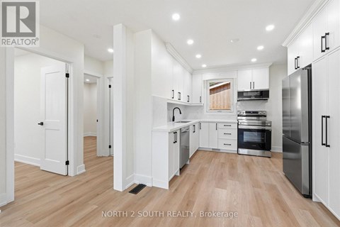A modern kitchen with white cabinets and stainless steel appliances.