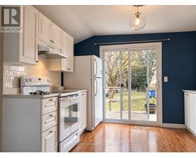 A kitchen with white appliances and wooden floors.