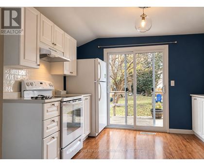 A kitchen with white appliances and wooden floors.
