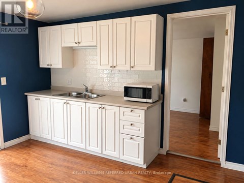 A kitchen with white cabinets and a blue wall.