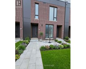 A modern brick building with a garden in front.