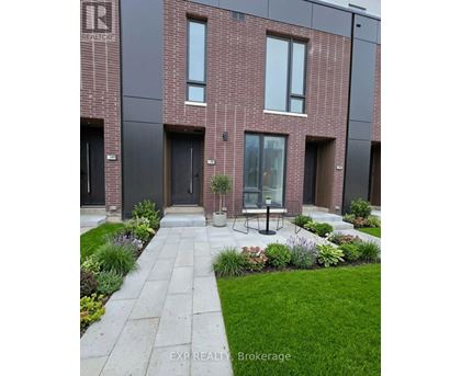 A modern brick building with a garden in front.