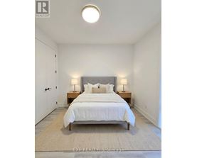 A bedroom with a bed, nightstands, and a rug.