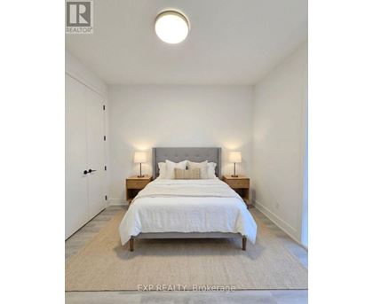 A bedroom with a bed, nightstands, and a rug.