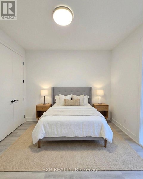 A bedroom with a bed, nightstands, and a rug.