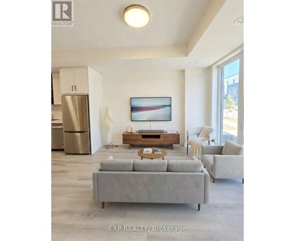 A modern living room with a grey sofa and a painting on the wall.