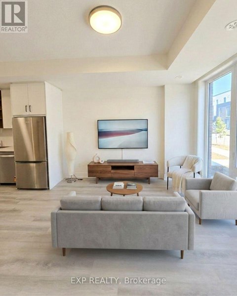 A modern living room with a grey sofa and a painting on the wall.