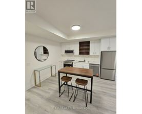 A kitchen with white cabinets and a wooden table.