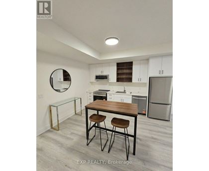A kitchen with white cabinets and a wooden table.