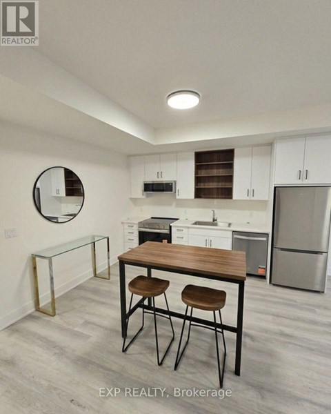 A kitchen with white cabinets and a wooden table.