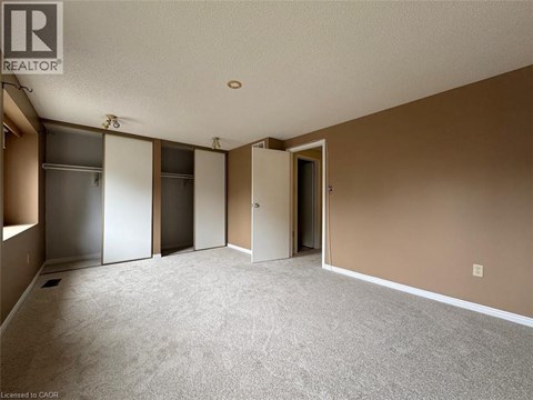A room with a carpeted floor and a wall-mounted refrigerator.