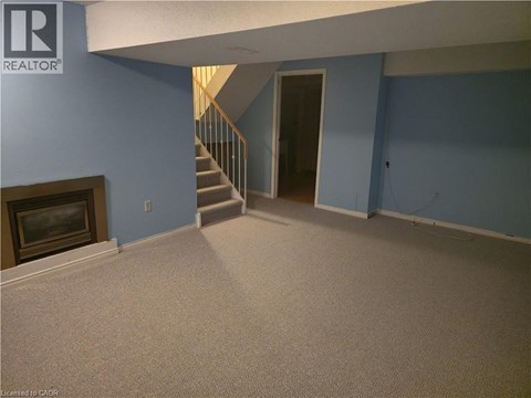 A living room with a fireplace and a staircase.