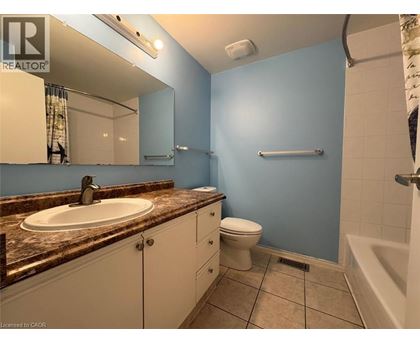 A bathroom with blue walls and a brown granite countertop.