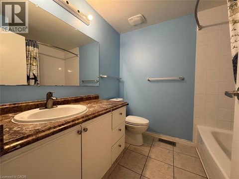 A bathroom with blue walls and a brown granite countertop.