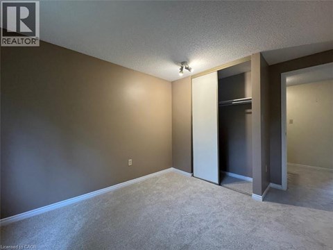 A room with a carpeted floor and a doorway leading to another room.