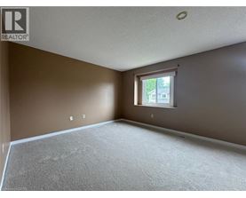 A room with a window and a carpeted floor.