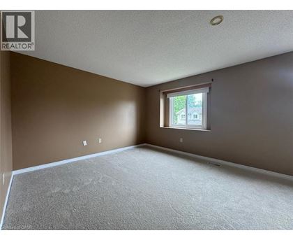 A room with a window and a carpeted floor.