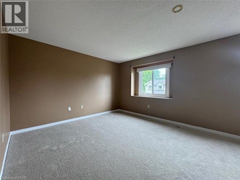 A room with a window and a carpeted floor.