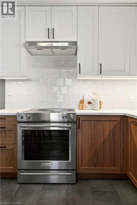 A modern kitchen with a stainless steel oven and wooden cabinets.
